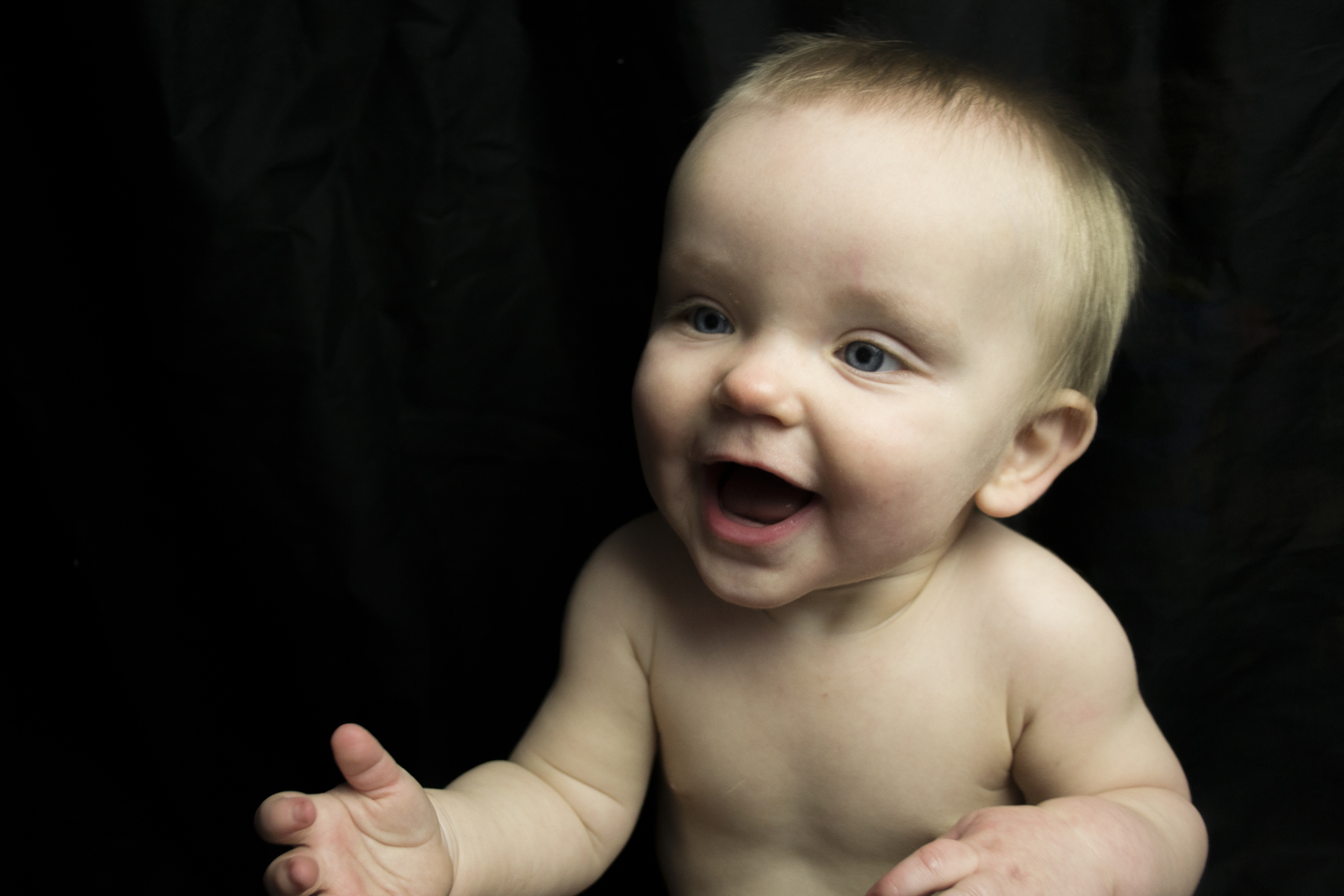 studio portrait of small baby on black background